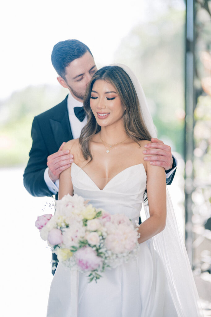 Bride and groom share an intimate moment at Greystone Mansion’s grand staircase, surrounded by historic architecture.